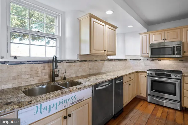 a kitchen with stainless steel appliances granite countertop a sink stove and microwave