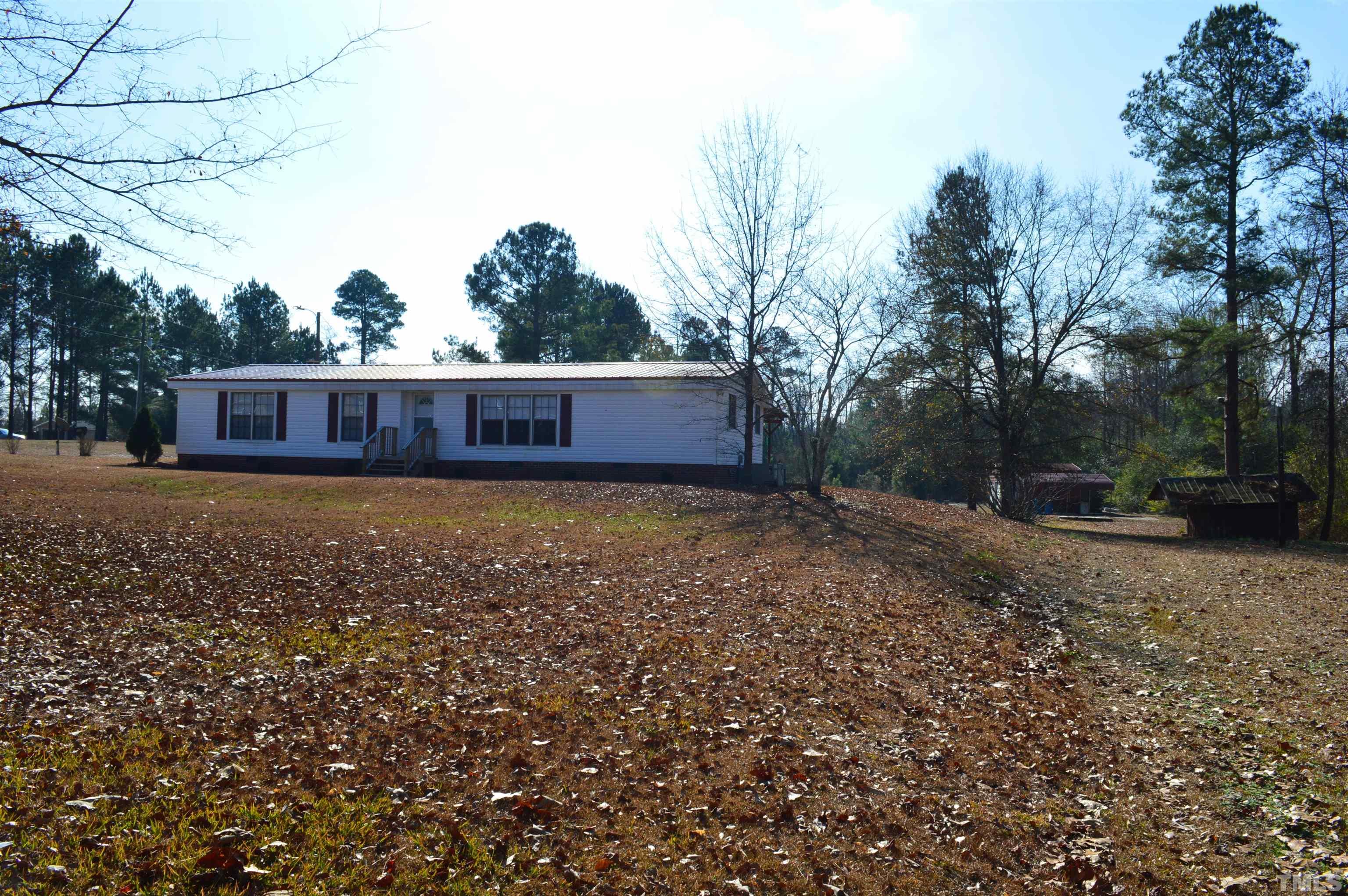 768 Wise Road Dunn, NC 28334 - Photo 3 of 28 a view of a backyard with large trees and wooden fence