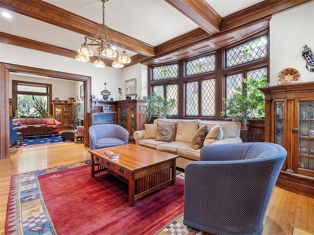 6417 Darlington Road Pittsburgh, PA 15217 - Photo 13 of 40 a living room with furniture a chandelier fan and a dining table with wooden floor