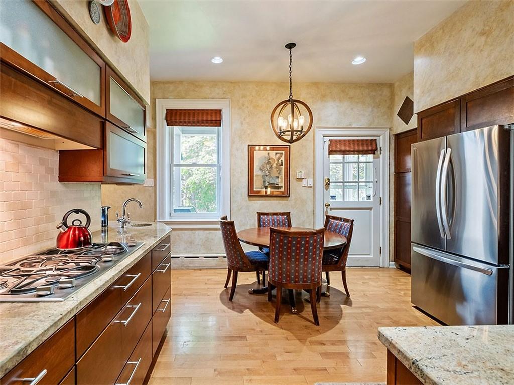 6417 Darlington Road Pittsburgh, PA 15217 - Photo 18 of 40 a kitchen with stainless steel appliances granite countertop a stove a refrigerator a kitchen island a dining table and chairs with wooden floor
