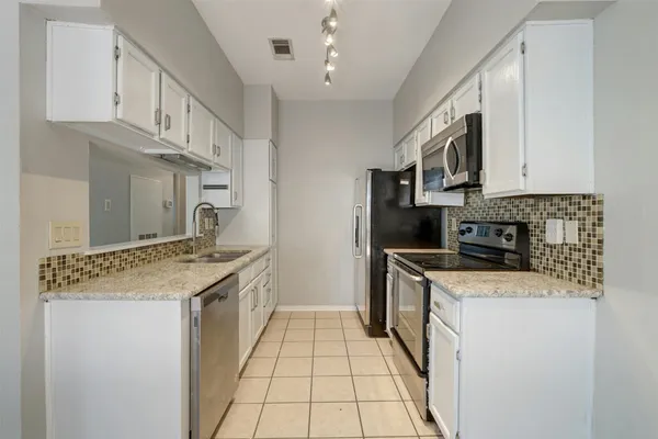 a kitchen with stainless steel appliances granite countertop a sink stove and cabinets