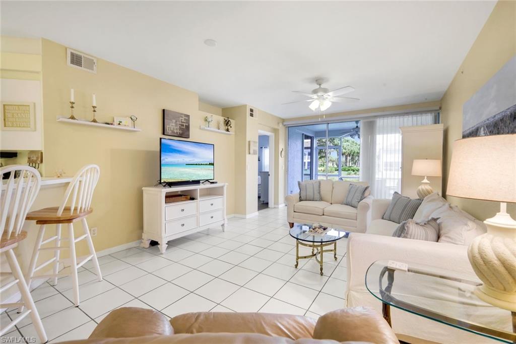 23810 Marbella Bay Road, Unit 103 Estero, FL 34135 - Photo 2 of 32 a living room with furniture and a flat screen tv