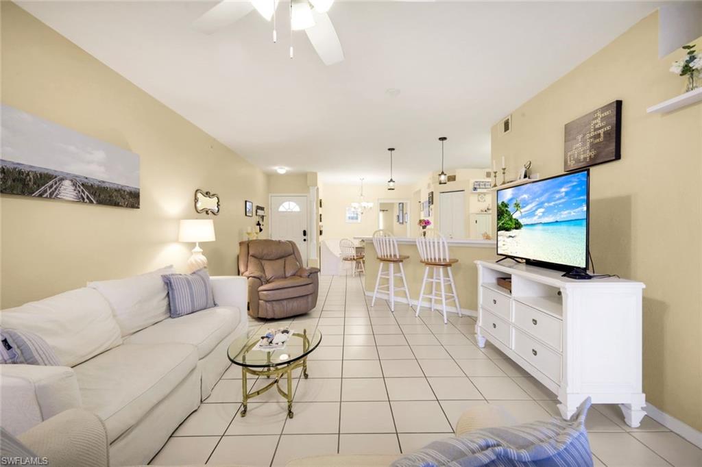 23810 Marbella Bay Road, Unit 103 Estero, FL 34135 - Photo 3 of 32 a living room with furniture and a flat screen tv