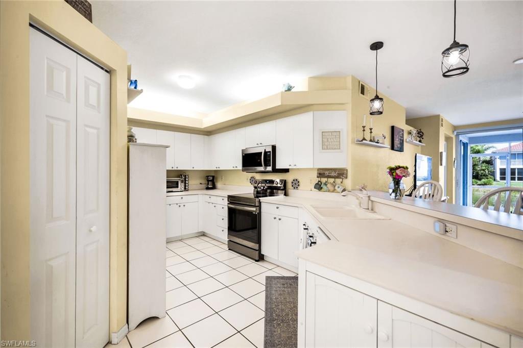 23810 Marbella Bay Road, Unit 103 Estero, FL 34135 - Photo 6 of 32 a kitchen with a sink a counter top space and appliances