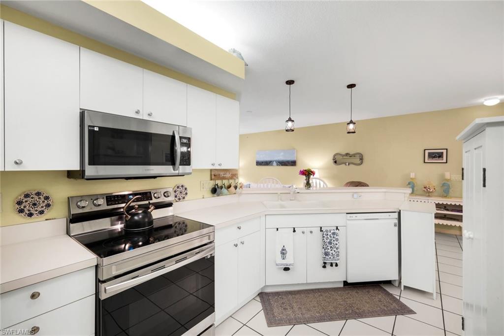 23810 Marbella Bay Road, Unit 103 Estero, FL 34135 - Photo 7 of 32 a kitchen with a sink and a stove top oven