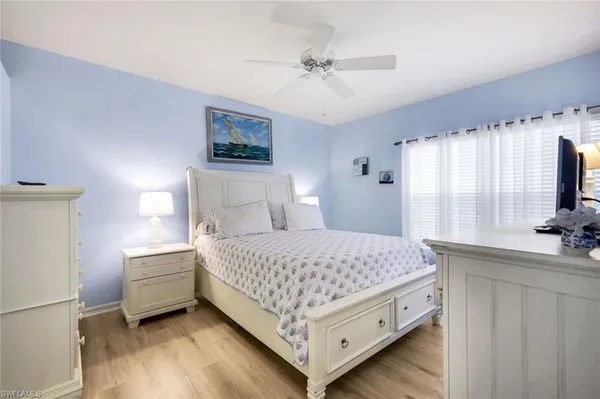 a bedroom with a bed and a flat tv screen on dresser