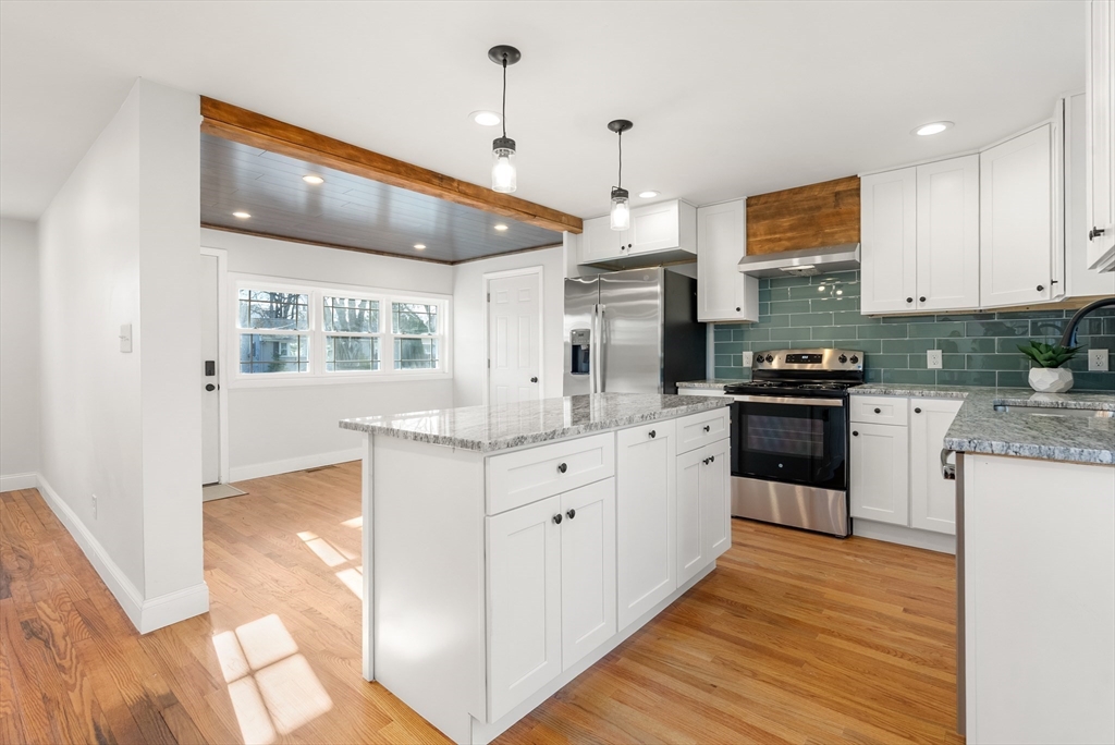 48 Beeler Avenue Chicopee, MA 01020 - Photo 3 of 30 a kitchen with stainless steel appliances kitchen island granite countertop a sink cabinets and wooden floor