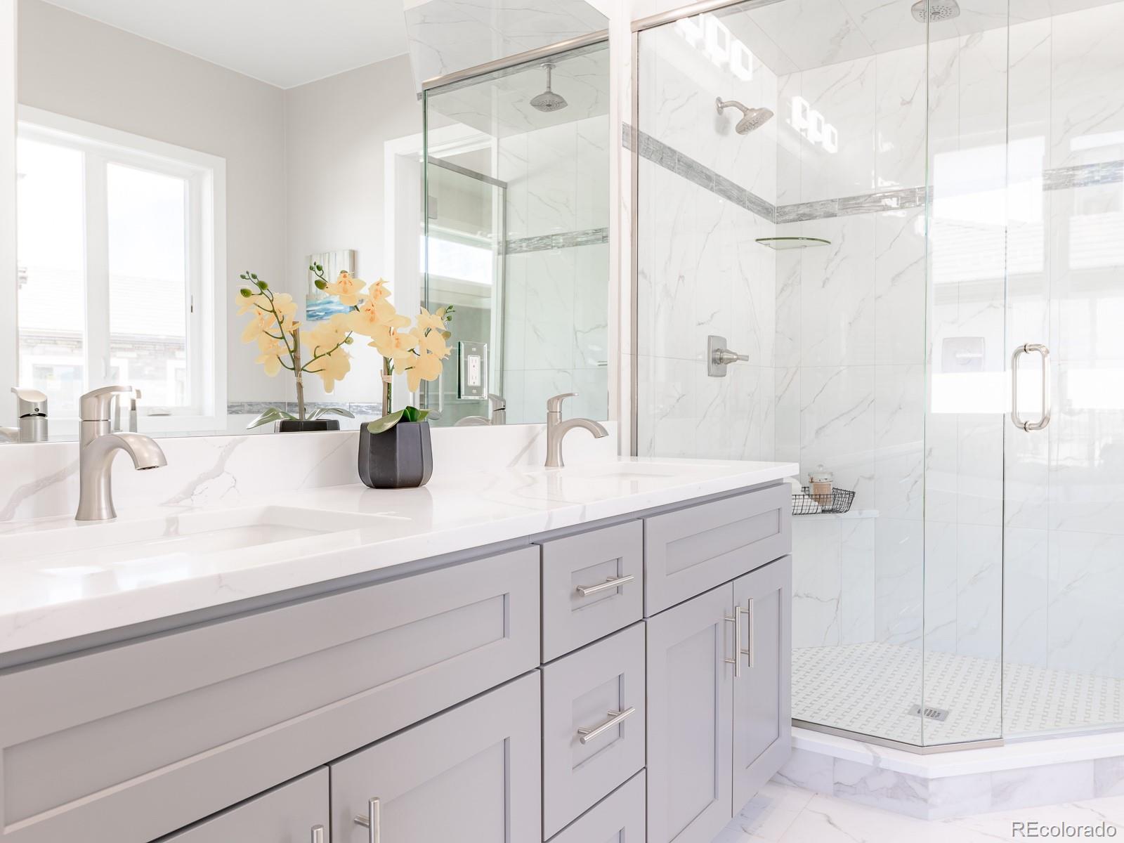 9540 Orion Way Arvada, CO 80007 - Photo 19 of 40 a bathroom with a double vanity sink mirror and shower