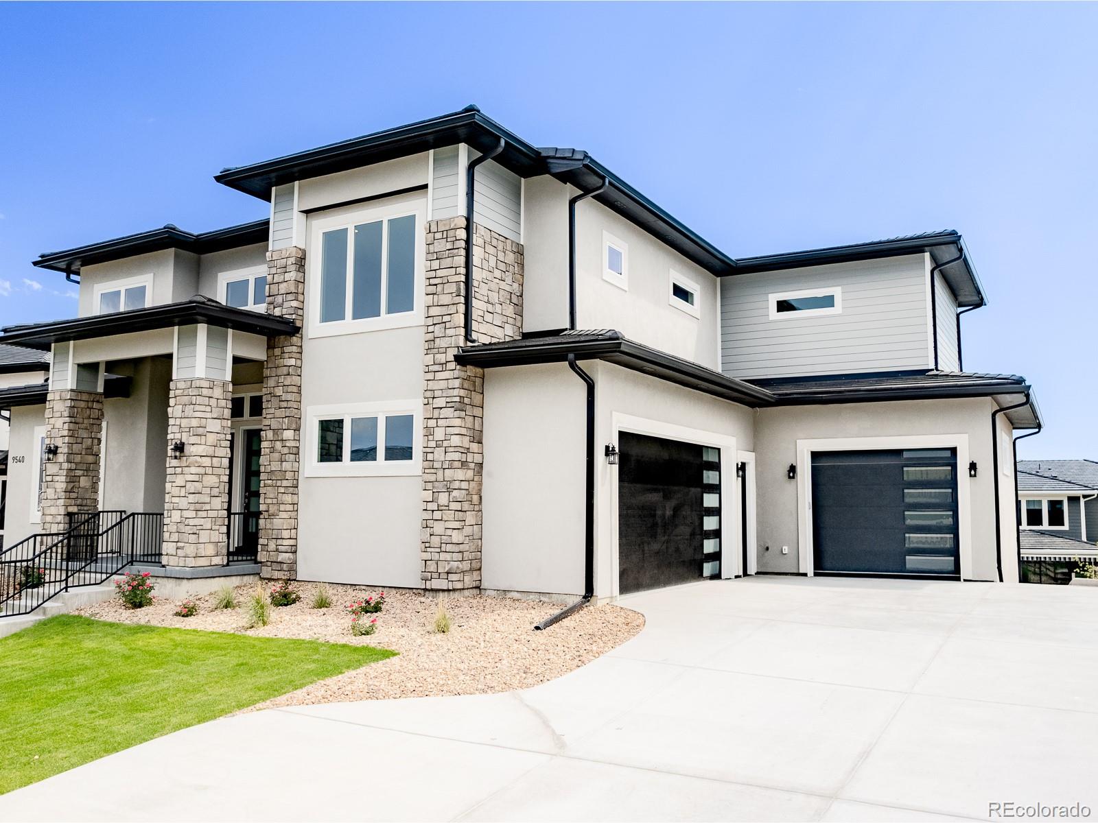 9540 Orion Way Arvada, CO 80007 - Photo 2 of 40 a front view of a house with a yard and garage