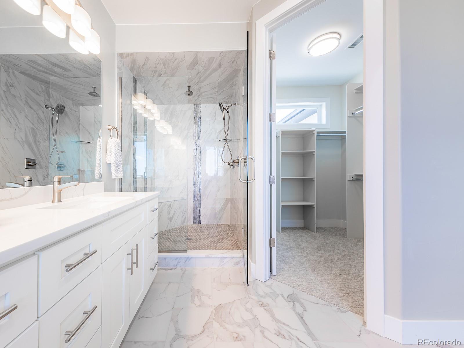 9540 Orion Way Arvada, CO 80007 - Photo 25 of 40 a spacious bathroom with a shower sink and mirror