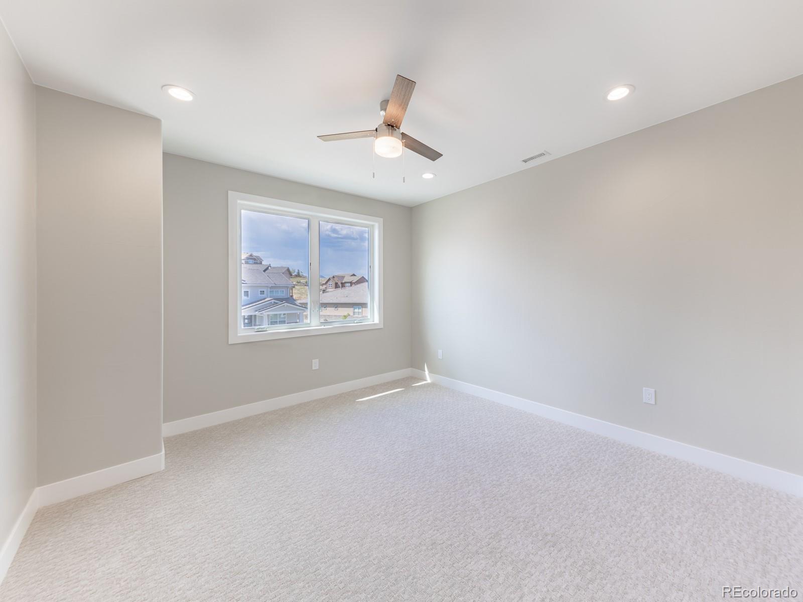 9540 Orion Way Arvada, CO 80007 - Photo 26 of 40 an empty room with windows and fan