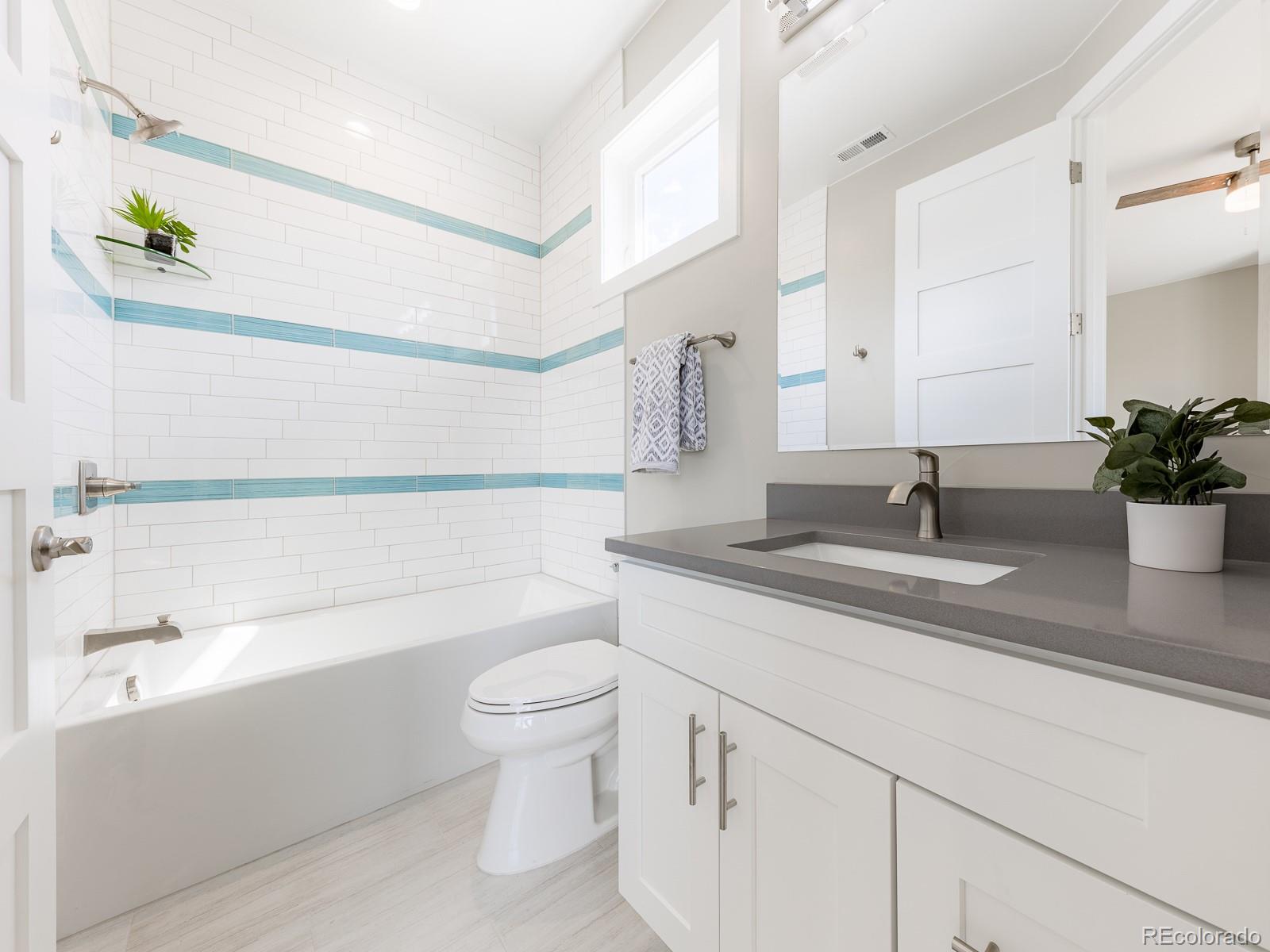 9540 Orion Way Arvada, CO 80007 - Photo 29 of 40 a bathroom with a granite countertop sink a toilet and bathtub