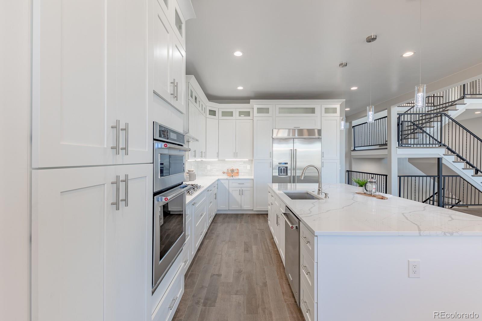 9540 Orion Way Arvada, CO 80007 - Photo 4 of 40 a kitchen with white cabinets and white appliances