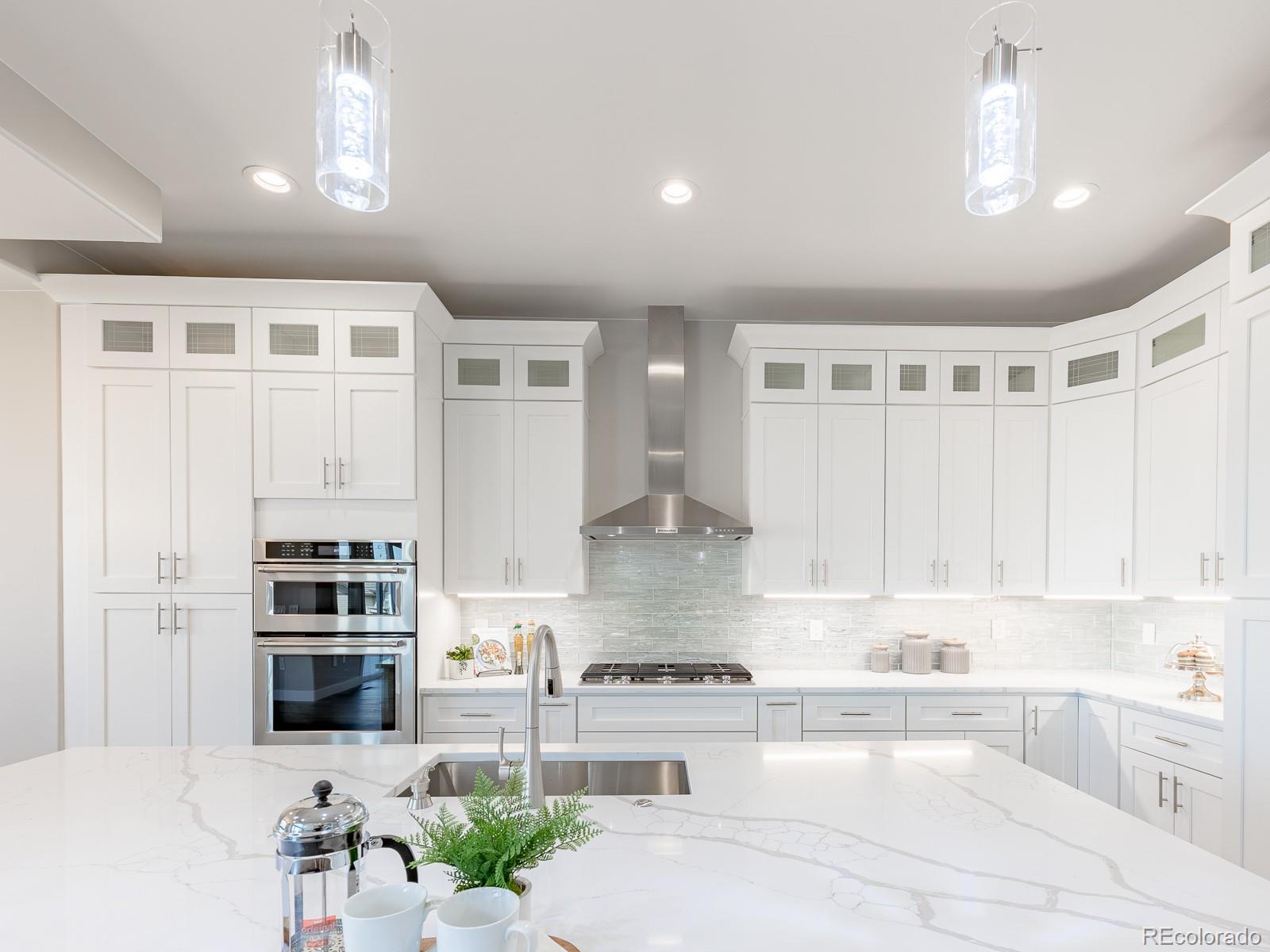 9540 Orion Way Arvada, CO 80007 - Photo 5 of 40 a kitchen with stainless steel appliances kitchen island granite countertop a refrigerator and a stove top oven