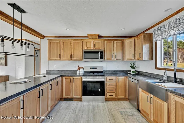 a kitchen with stainless steel appliances granite countertop a stove a sink and a microwave