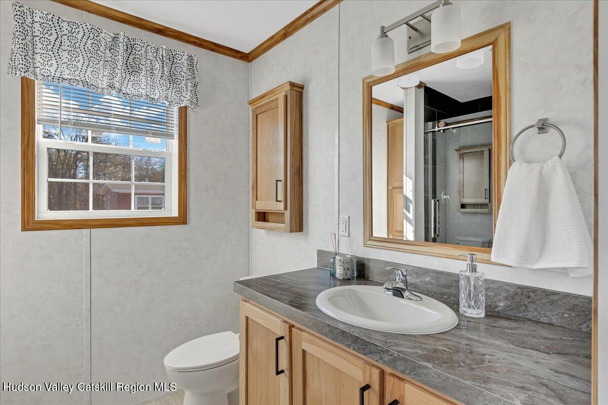 299 Hyspot Road, Unit 4C Greenfield, NY 12833 - Photo 28 of 41 a bathroom with a granite countertop toilet a sink and a mirror