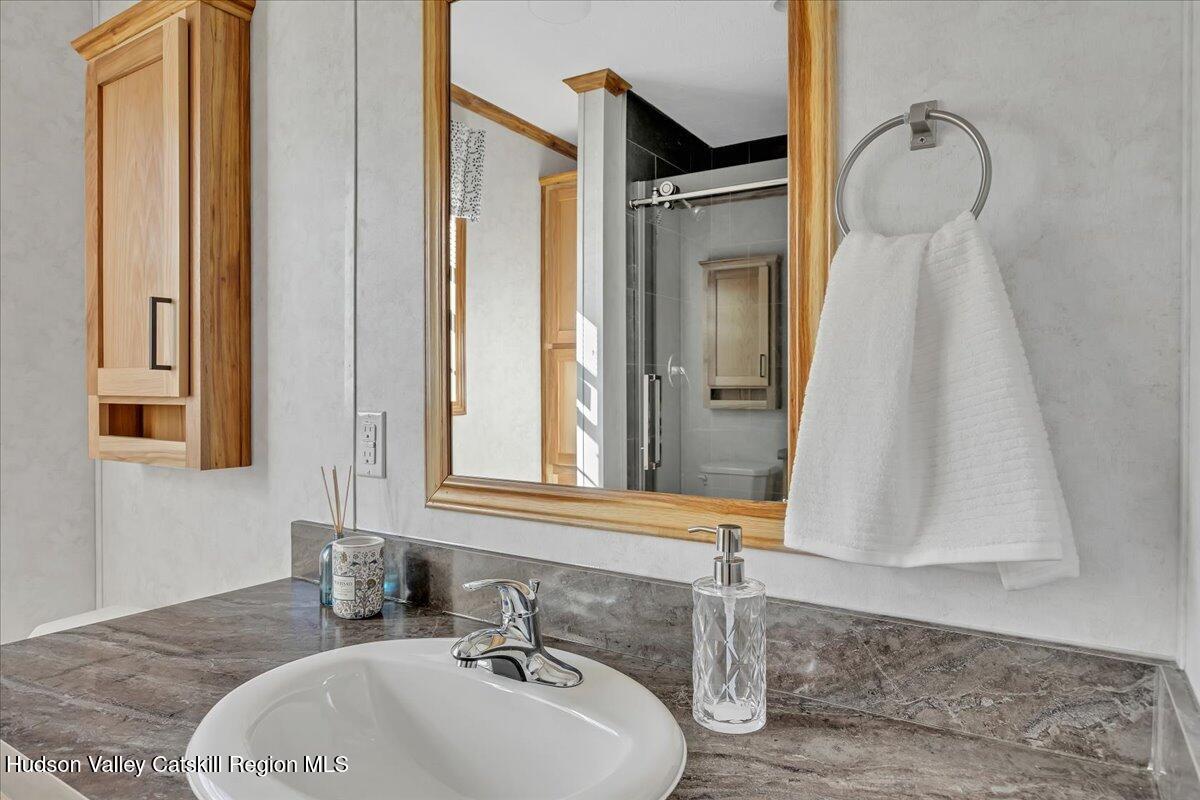 299 Hyspot Road, Unit 4C Greenfield, NY 12833 - Photo 29 of 41 a bathroom with a sink and a mirror