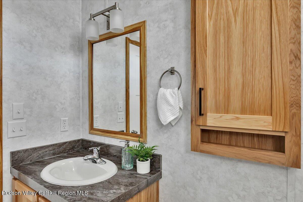 299 Hyspot Road, Unit 4C Greenfield, NY 12833 - Photo 36 of 41 a bathroom with a sink a mirror and a shower