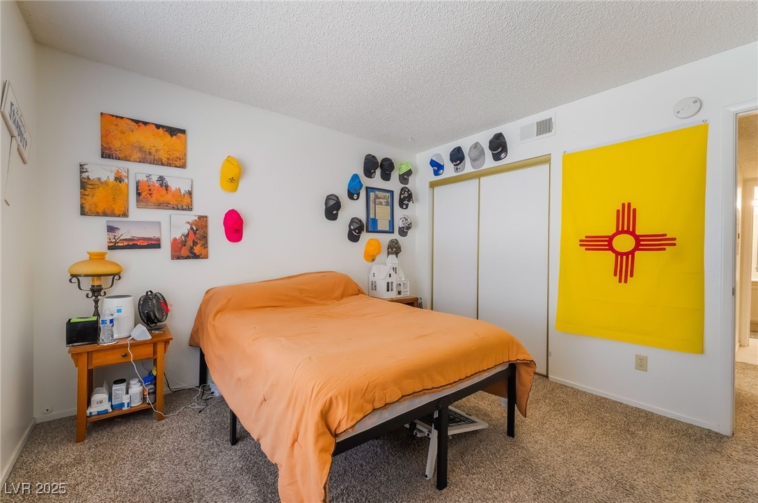 1575 West Warm Springs Road, Unit 2822 Henderson, NV 89014 - Photo 30 of 37 Bedroom with carpet, a textured ceiling, a closet, and baseboards