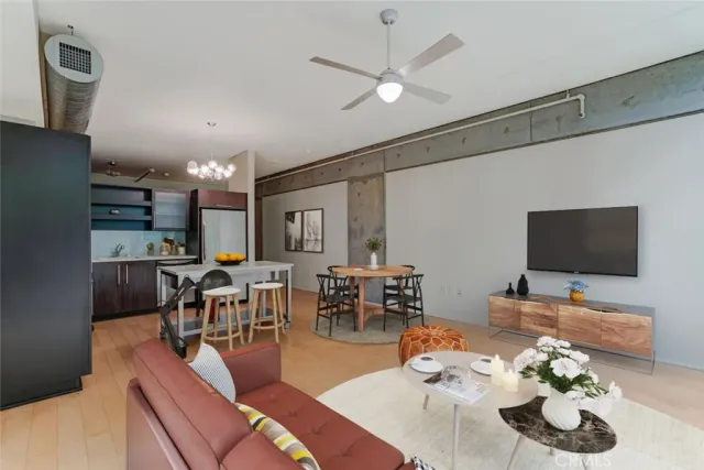 a living room with furniture kitchen view and a flat screen tv