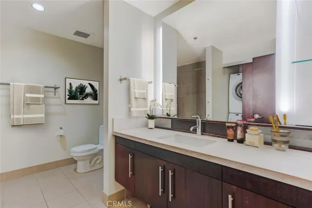 a bathroom with a double vanity sink toilet and a mirror