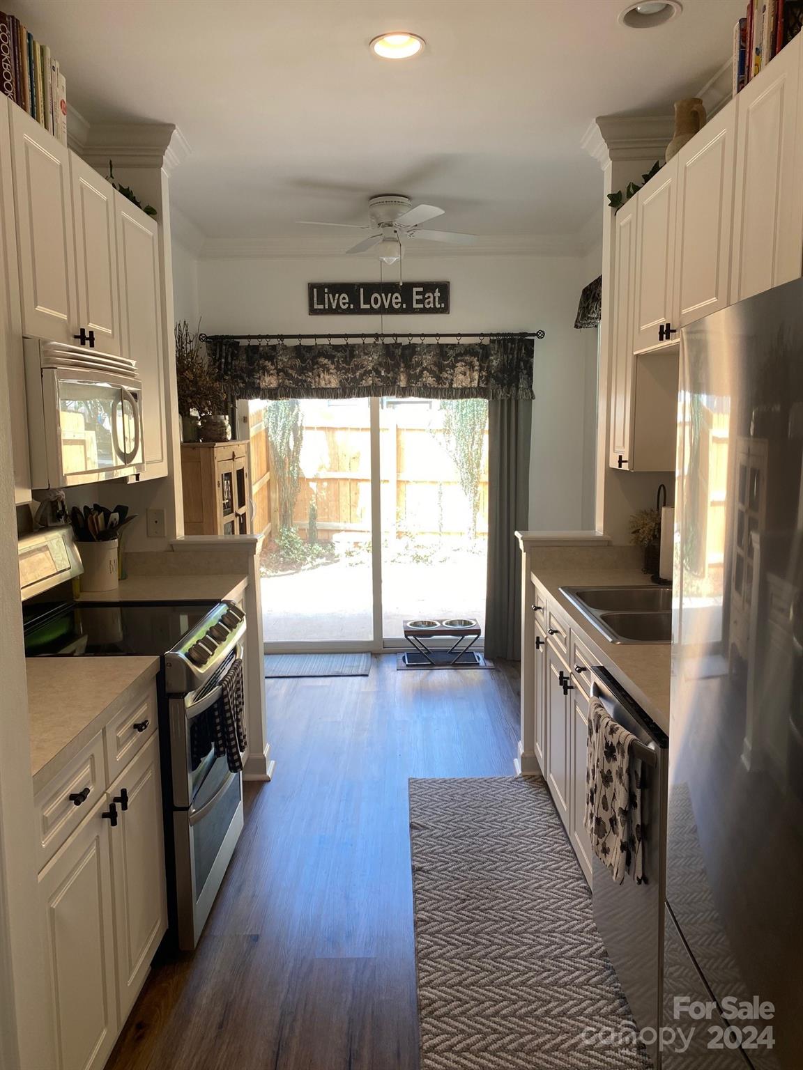 18225 Taffrail Way Cornelius, NC 28031 - Photo 10 of 30 a kitchen with granite countertop a stove top oven a sink dishwasher a refrigerator and a fireplace