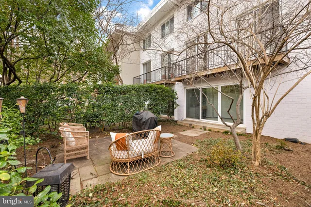 front view of a house with a chairs and table in the patio