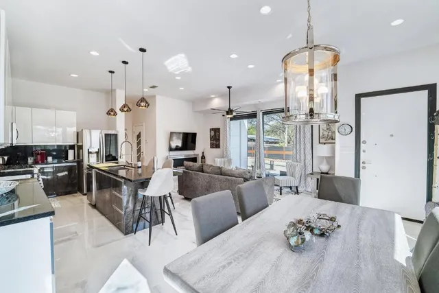 a living room with furniture kitchen view and a chandelier