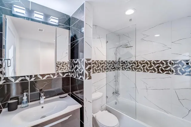 a bathroom with a sink vanity mirror and toilet