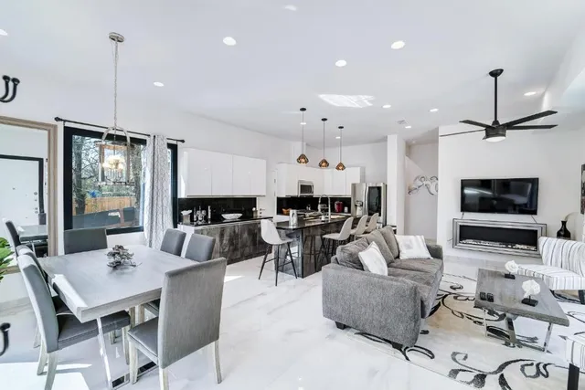 a living room with furniture kitchen view and a flat screen tv