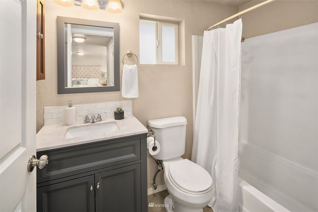 a bathroom with a granite countertop toilet sink and mirror