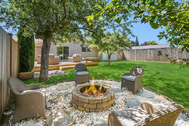 a backyard of a house with garden and outdoor seating