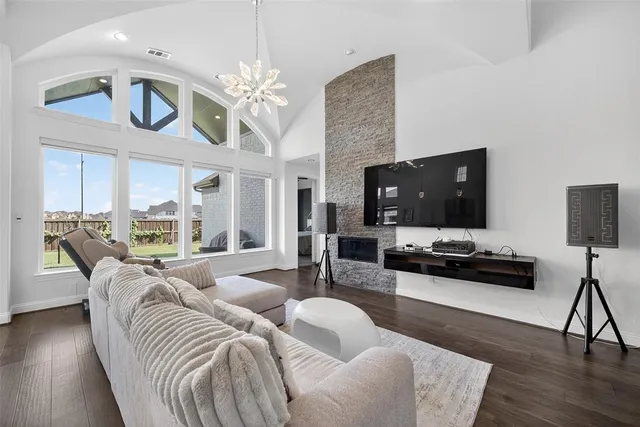 a living room with furniture a chandelier and a flat screen tv
