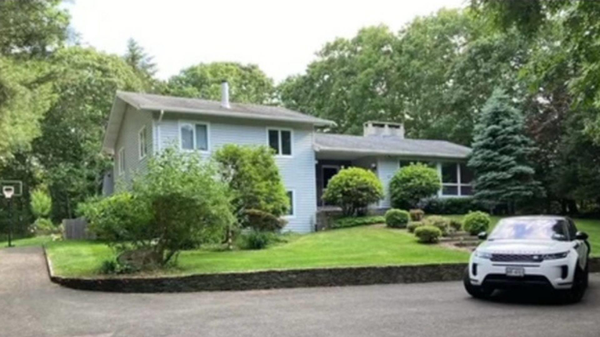 Split level home with driveway and a front lawn