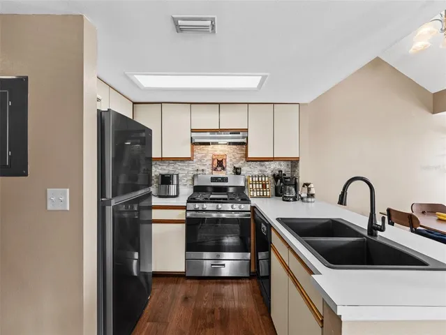 a kitchen with a refrigerator sink and cabinets