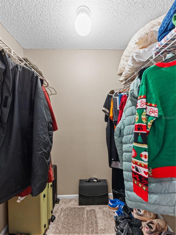 7705 Waterview Way, Unit 7705 Winter Haven, FL 33884 - Photo 17 of 33 a view of walk in closet with clothes and shoes