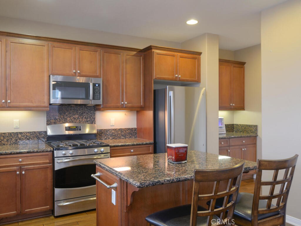 128 Lopez Way Hemet, CA 92545 - Photo 6 of 36 a kitchen with stainless steel appliances granite countertop a stove a refrigerator a microwave a sink and cabinets