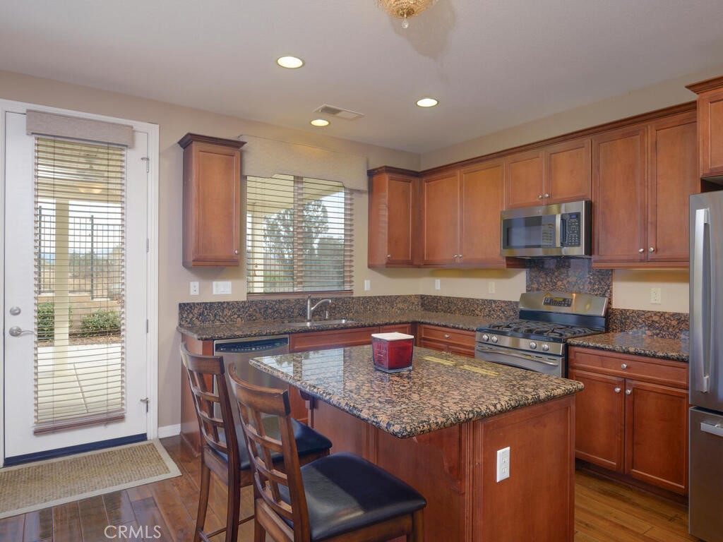 128 Lopez Way Hemet, CA 92545 - Photo 7 of 36 a kitchen with granite countertop kitchen island stainless steel appliances a sink stove and microwave