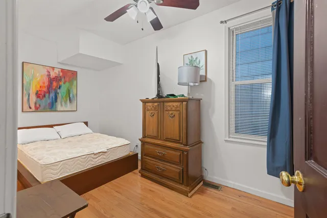 a room with a bed and wooden floor