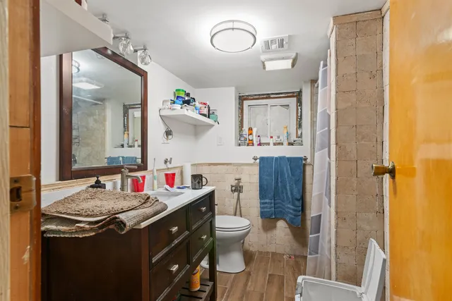 a bathroom with a sink vanity mirror and toilet