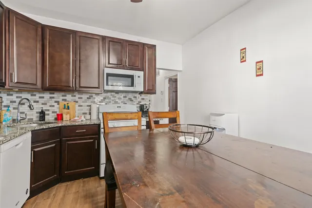 a kitchen with granite countertop a stove a sink and cabinets