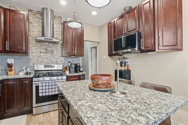 a kitchen with stainless steel appliances granite countertop a stove microwave and sink