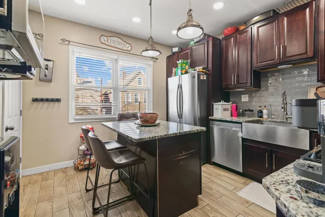 a kitchen with stainless steel appliances granite countertop a sink stove and refrigerator