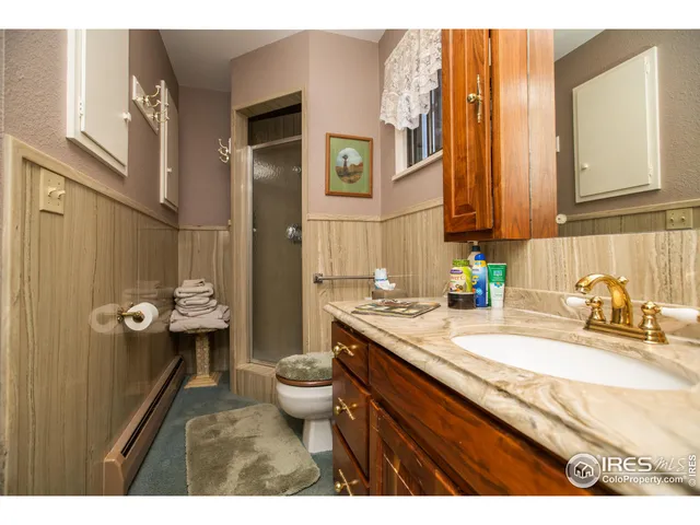 a bathroom with a granite countertop sink mirror vanity and toilet