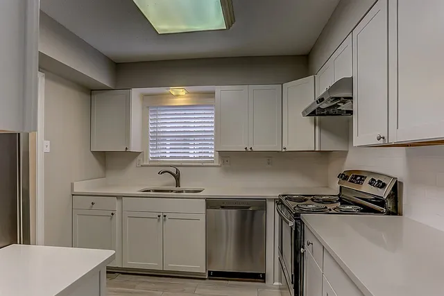a kitchen with white cabinets and white appliances