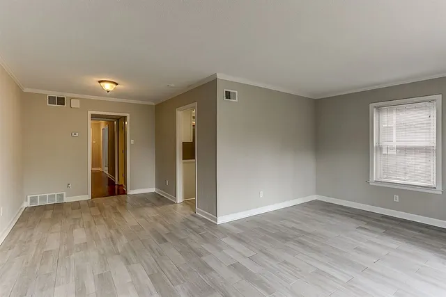 a view of empty room with wooden floor