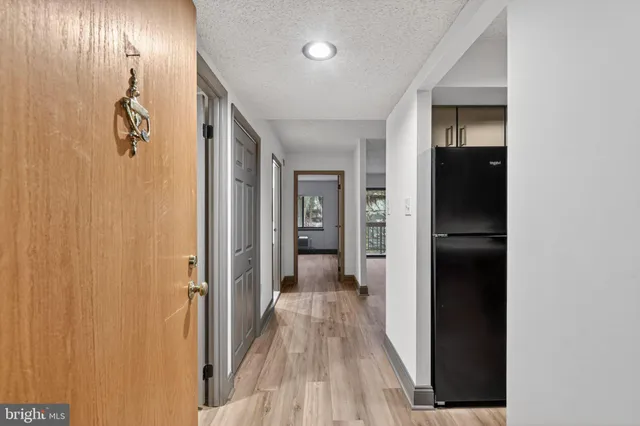 a view of a hallway with wooden floor and closet