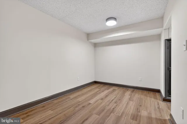a view of an empty room with wooden floor