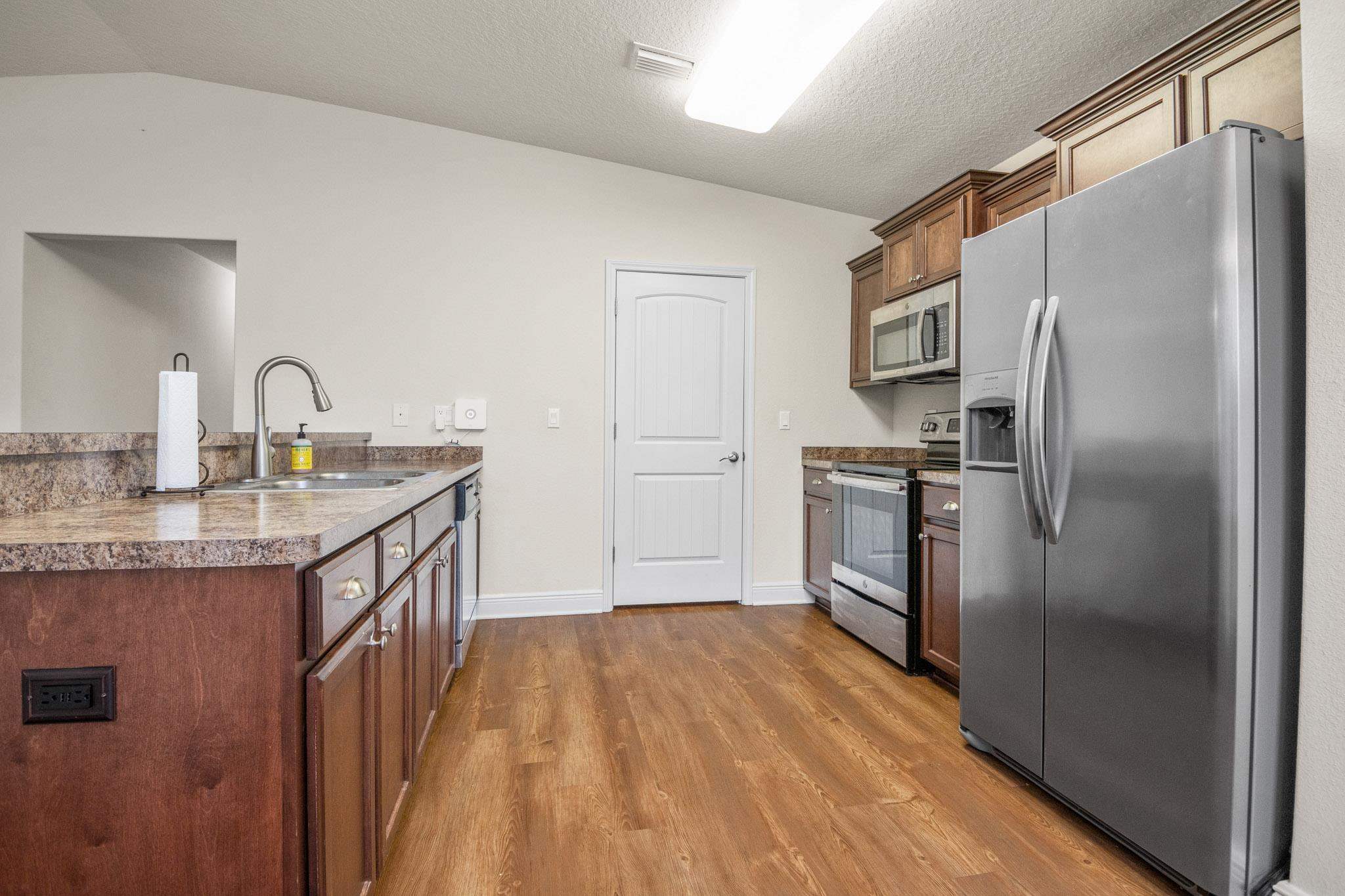 5070 Carmell Ridge Circle Milton, FL 32570 - Photo 11 of 36 a kitchen with kitchen island a counter top space a sink appliances and cabinets