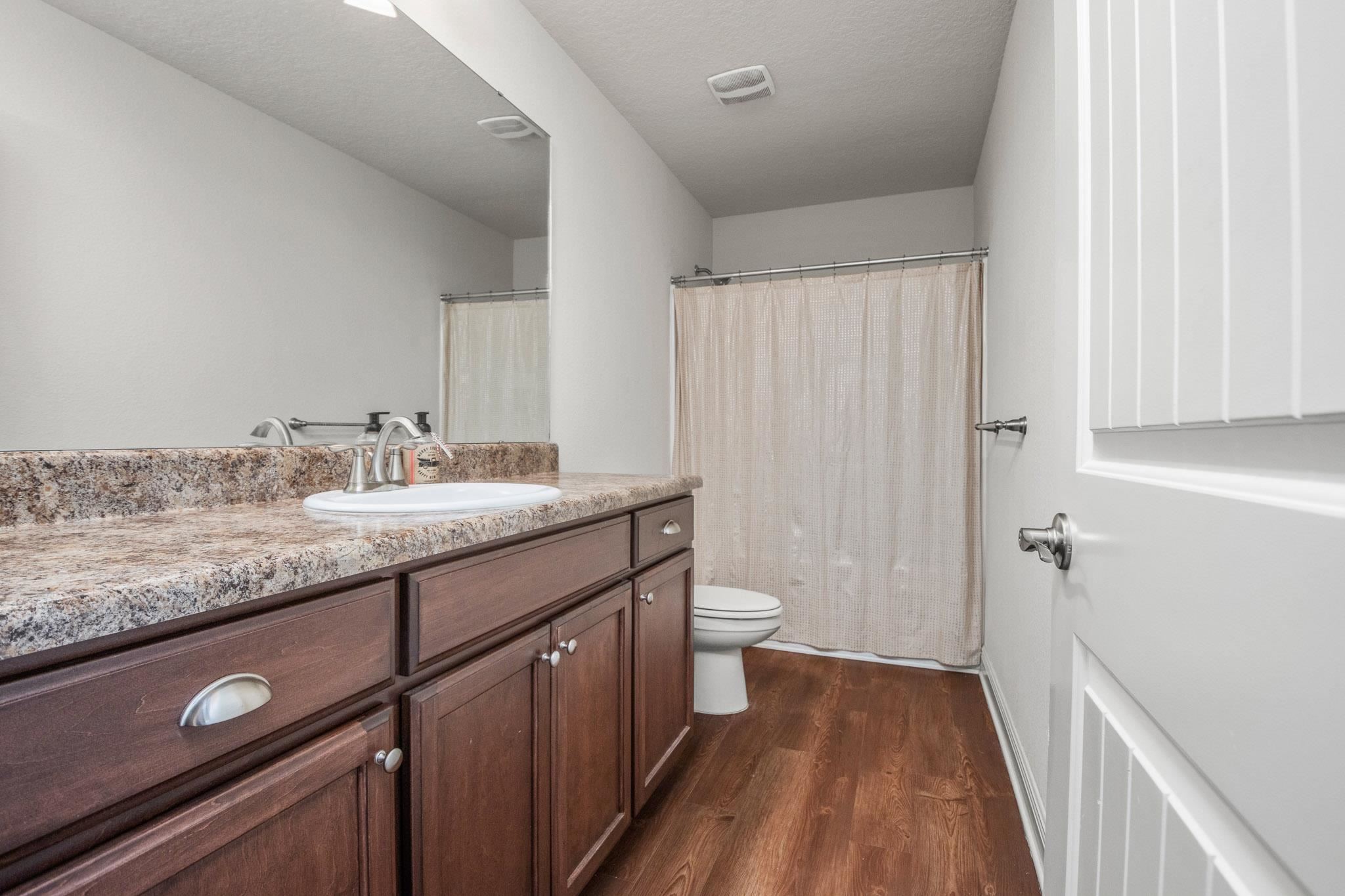 5070 Carmell Ridge Circle Milton, FL 32570 - Photo 16 of 36 a bathroom with a granite countertop sink toilet and shower curtains